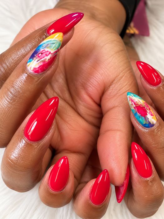 Red nails with colorful accent art at Showanda’s Nail Bar